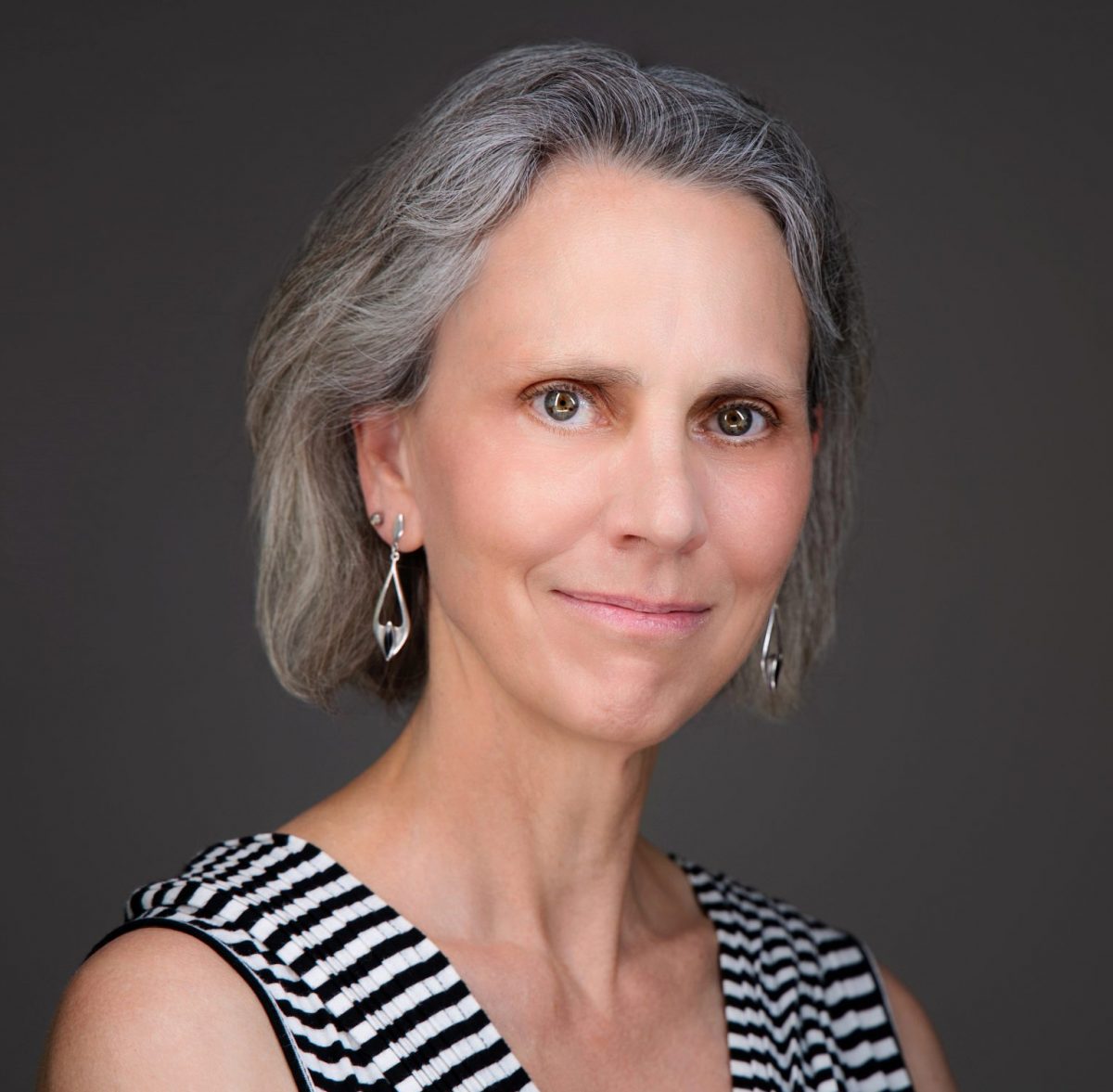 Headshot of Susanna Cowan, PBK Chapter President & Acting Secretary, wearing a no-sleeve, black-and-white striped top.
