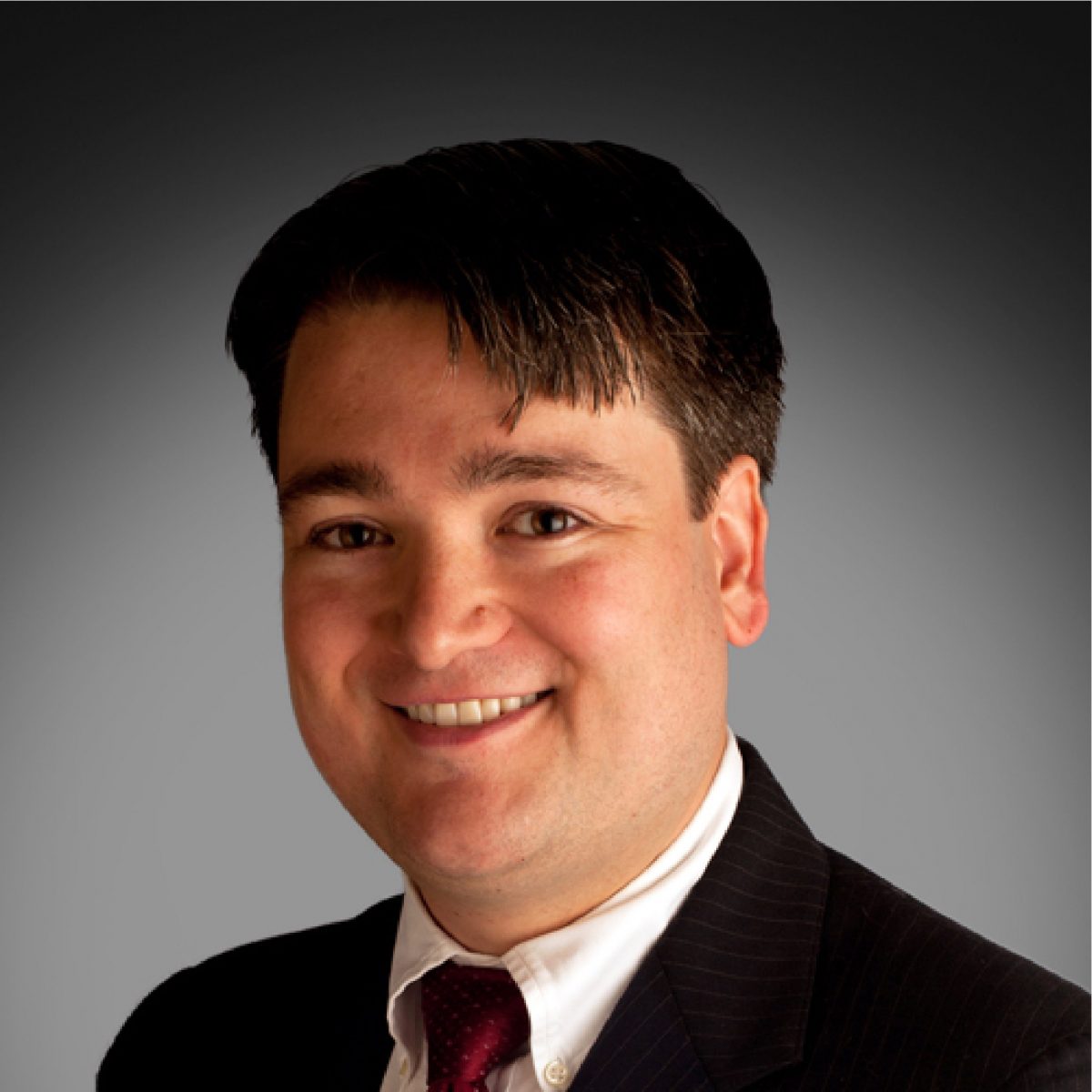 Headshot of Karl Muth, Chapter Treasurer, wearing a button-up shirt, tie, and suit jacket.