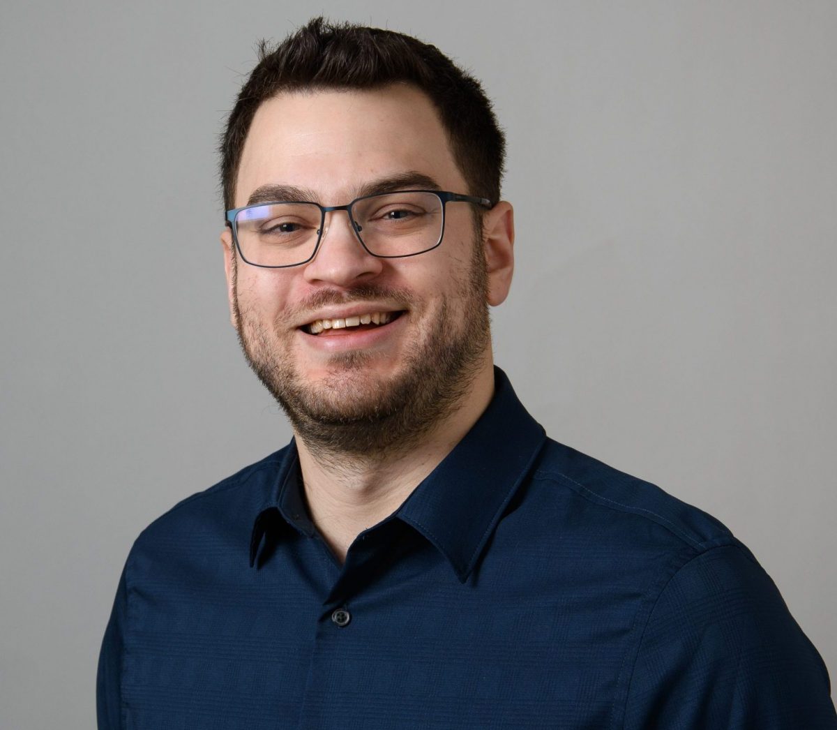 Headshot of Scott Rich, PBK chapter Historian, wearing glasses and a dark blue, button-up shirt.