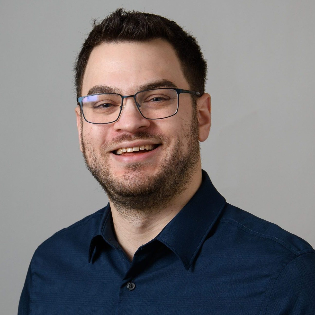 Headshot of Scott Rich, PBK chapter Historian, wearing glasses and a dark blue, button-up shirt.
